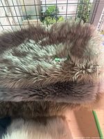 Stacked faux sheepskin rugs showing pile texture and colour