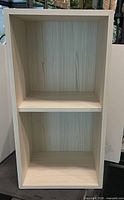 Front view of single white two-shelf bookcase