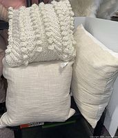 Front angle showing three of the pillows: knit bobble, slub-woven, ribbed-weave