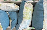 Group of all five pillows showing floral print and solid teal reverse fabrics