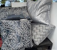 Three pillows: charcoal with embroidery, metallic silver pleated, light grey basket weave