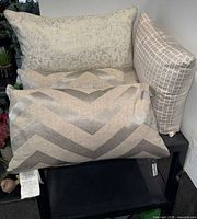 Stack of decorative pillows showing chevron, crushed-velvet and grid designs