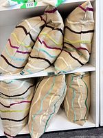 Six pillows stacked on shelf showing pattern and shape