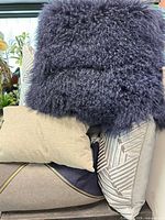 Group view showing navy faux fur pillow, silver geometric pillow, beige and navy pillows