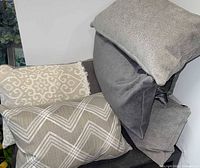 Stack of assorted neutral pillows showing four patterns
