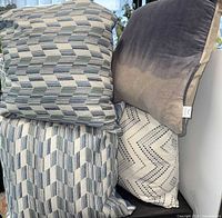 Stack of assorted patterned pillows showing three designs
