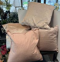 Four assorted pink pillows stacked showing velvet, linen and honeycomb patterns