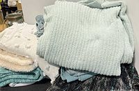 Stack of assorted throw blankets showing variety of textures and colors