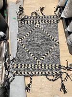 Black and white fringed rug on table