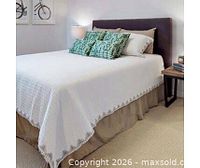 Staged bed displaying white quilt and beige accents