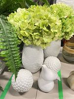 Pair of vases with faux hydrangeas, decorative sphere and bird visible