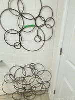 Both metal circle wall sculptures shown together for scale and design