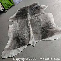 Full view of cowhide rug laid flat showing shape and color gradient