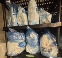 Multiple Ziploc Big Bags of folded white towels on shelving