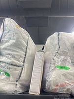 Two comforter sets and packaged sheet set on shelf