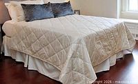 Bed made with beige quilted coverlet, illustrating texture and size
