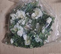 bagged silk floral wreath with white flowers and green leaves