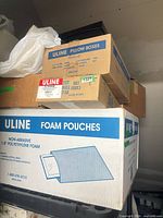 Closed cartons labeled Uline Pillow Boxes, 8×8×3 mailers and Foam Pouches stacked together