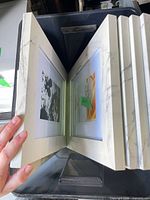Stack of white faux-marble finish frames opened to show inserts