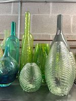 group of green and clear ribbed glass vases in varying heights