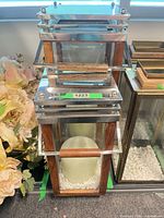 Lanterns stacked showing wood frames, stainless top, pillar candle and white stones