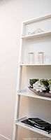 White leaning ladder desk/shelf with decorative items displayed