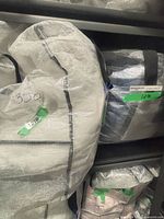 Bagged white pintuck comforter set labelled 350 and adjacent bagged navy set labelled 1270