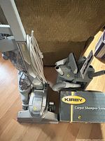 Upright vacuum, cord, attachment caddy, shampoo system box