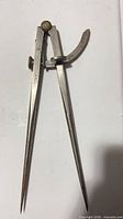Full view of metal wing divider compass