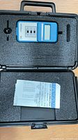 Meter and paperwork inside foam-lined carrying case