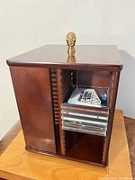 Full view of wooden rotating CD tower with CDs inside