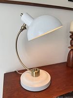 Side view of white dome desk lamp on wooden surface