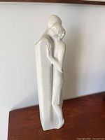 Front view of white stone lovers embrace sculpture
