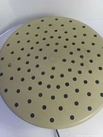 Top view of circular beige perforated housing