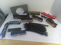 Group view of locomotive, freight and tanker cars, caboose, track, bridge and tunnel portal