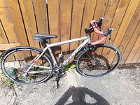 Full left-side view of KHS Flite 500 bicycle leaning against fence