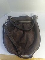 Front view showing overall shape, leather texture, zipper pocket and strap attachments