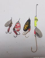 Overview of four fishing lures hanging on white background