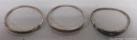 Three hinged bangle bracelets laid flat showing interiors
