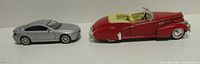 Side view of both model cars showing scale and condition
