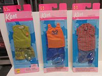 Front view of three sealed Ken outfit packs