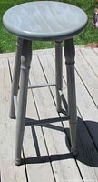 Front view of grey wooden bar stool on deck