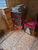 group of boxed Christmas items including tree box, patterned storage boxes and tree kit