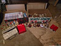 Overview of boxes containing light sets, ornaments, music boxes on floor