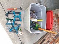 Tote with lid and array of garden tools and sprinklers laid out