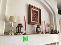 Overall shelf with lamps, lanterns, candlesticks, framed art, figurines