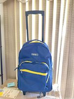 Front view of blue rolling backpack showing telescopic handle and yellow accented zippers