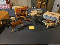 Group of Breyer horses and boxes on table