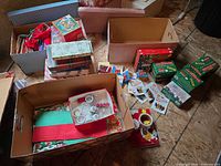 assorted boxes with wrapping supplies, stocking, tea lights, lights, window clings