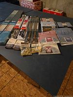 group shot of all sealed curtain rods, brackets, clips, mini blinds, curtain panels, shower curtains, and sheets on table